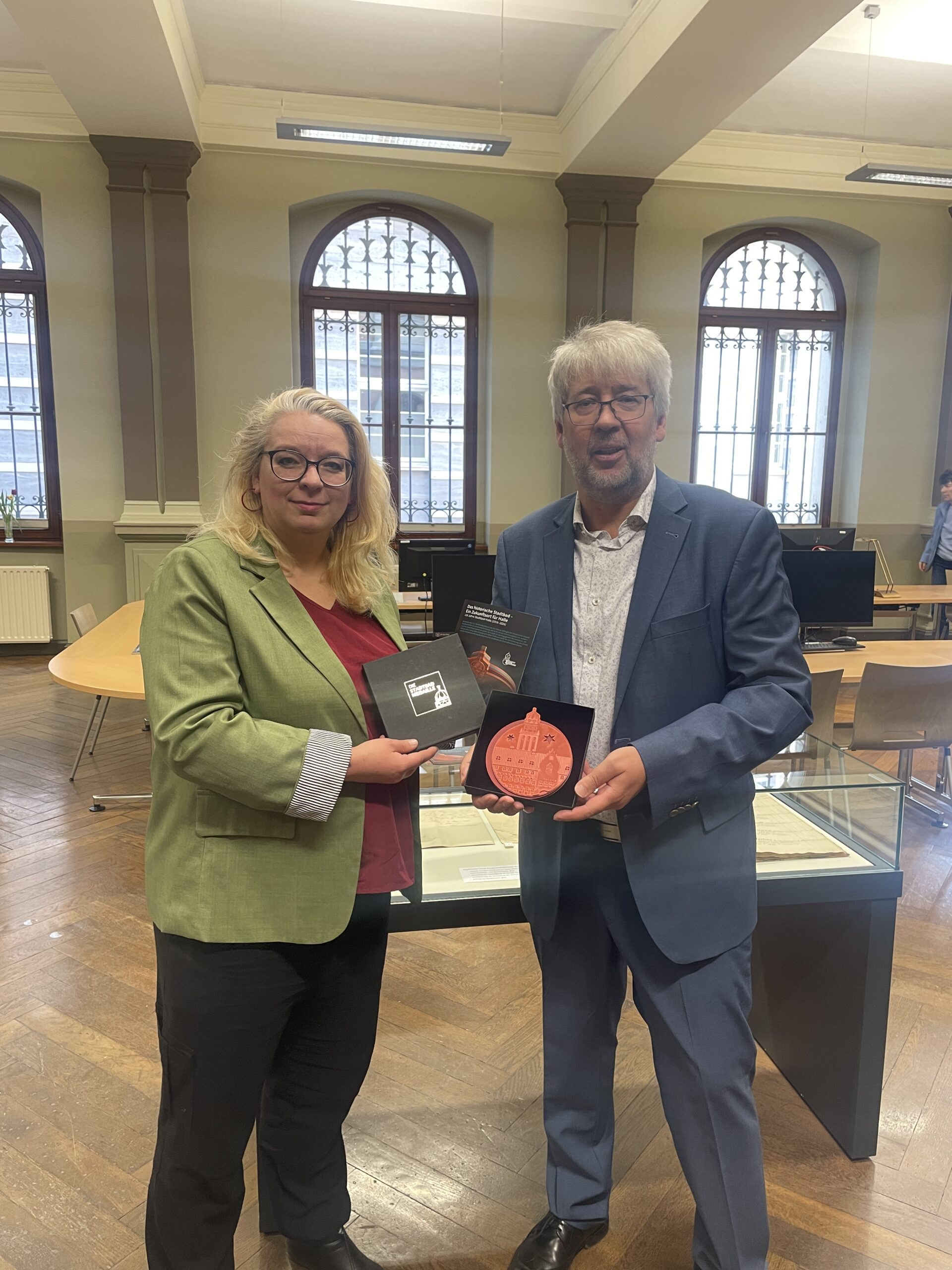 Übergabe eines Exemplars der Medaille in die Sammlung des Stadtarchivs. Zu sehen sind die Vorsitzende des Fördervereins, Kathleen Hirschnutz, und der Leiter des Stadtarchovs, Ralf Jacob.